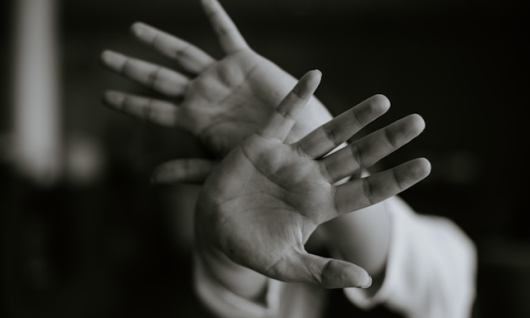 hands blocking the camera lens to show anxiety