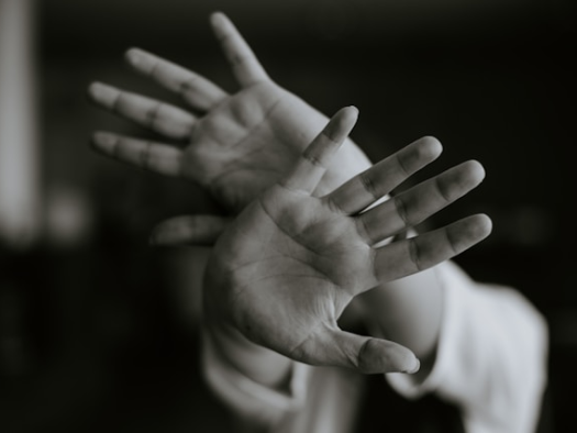hands blocking the camera lens to show anxiety